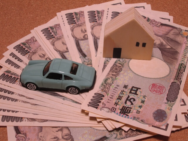 家と車の置物とお金